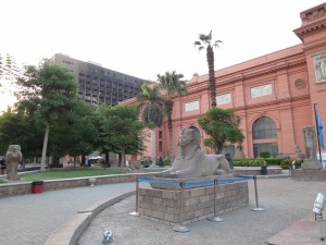 A blackened, burned-out building beside and behind the Cairo Museum