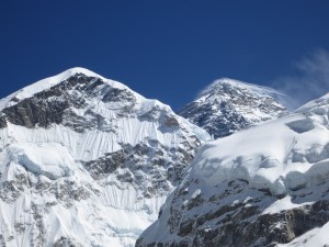 Whispy snow drifts being blown off the summit of Everest (right)