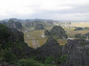 The view across the flooded rice paddies and limestone karst towers towards Ninh Binh, as seen from the top of the climb above Hang Mua The view across the flooded rice paddies and limestone karst towers towards Ninh Binh, as seen from the top of the climb above Hang Mua