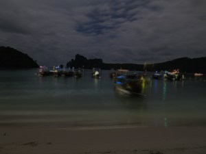 Longtails floating on the water at night in Loh Da Lum Bay